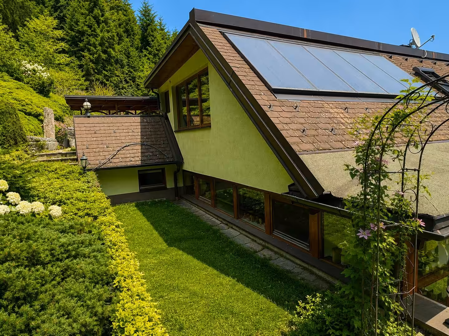 Hausansicht in grüner Gartenlandschaft