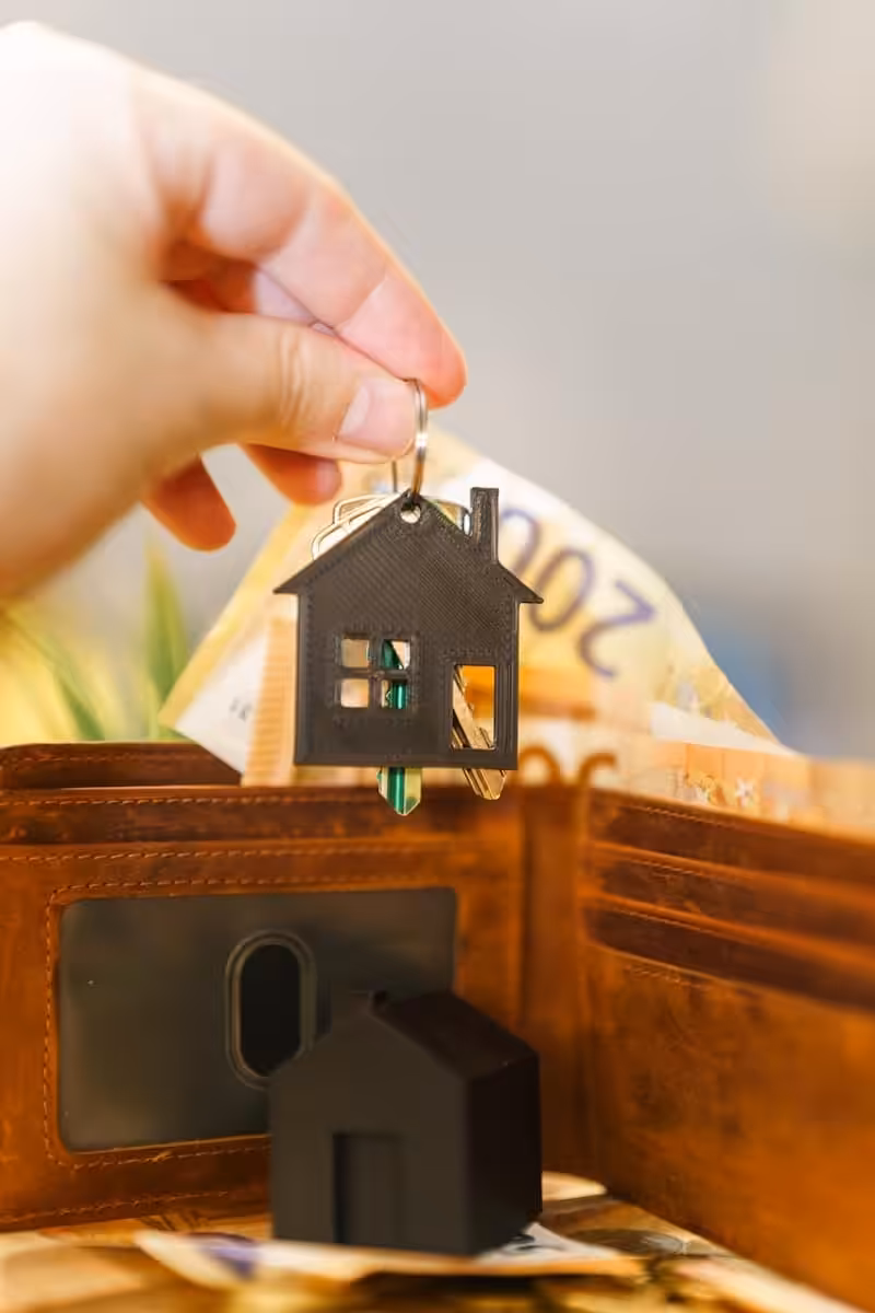 Anlegerwohnung A person putting a house key into a wallet