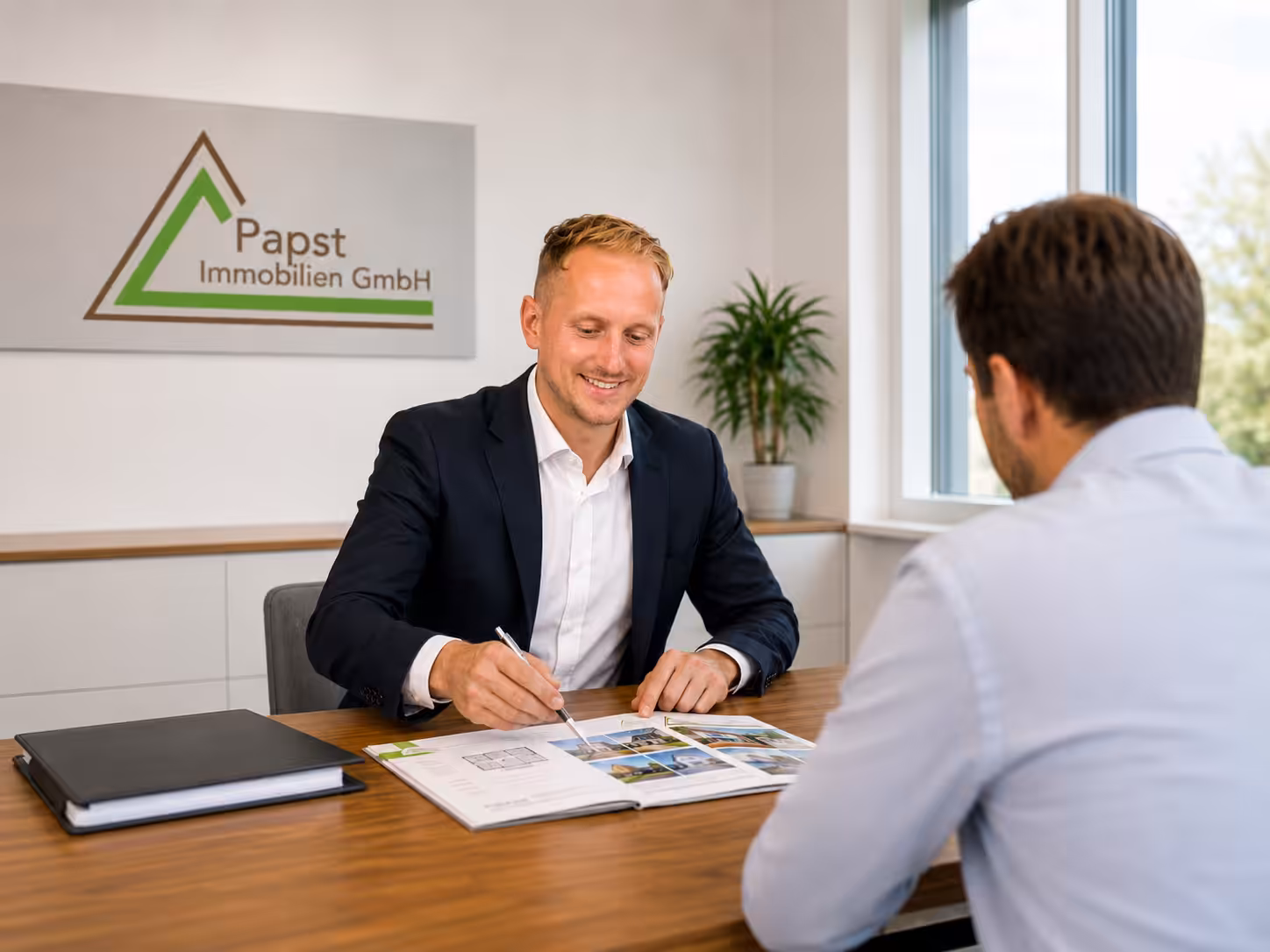 Patrick Großschädl von Papst Immobilien bei einer persönlichen Immobilienberatung mit einem Kunden in Graz.